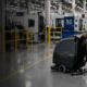 Industrial facility cleaning in a Kitchener manufacturing facility with floor scrubber and safety-marked production area